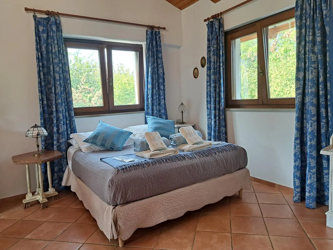 Double bed with cotton sheets and windows overlooking the greenery