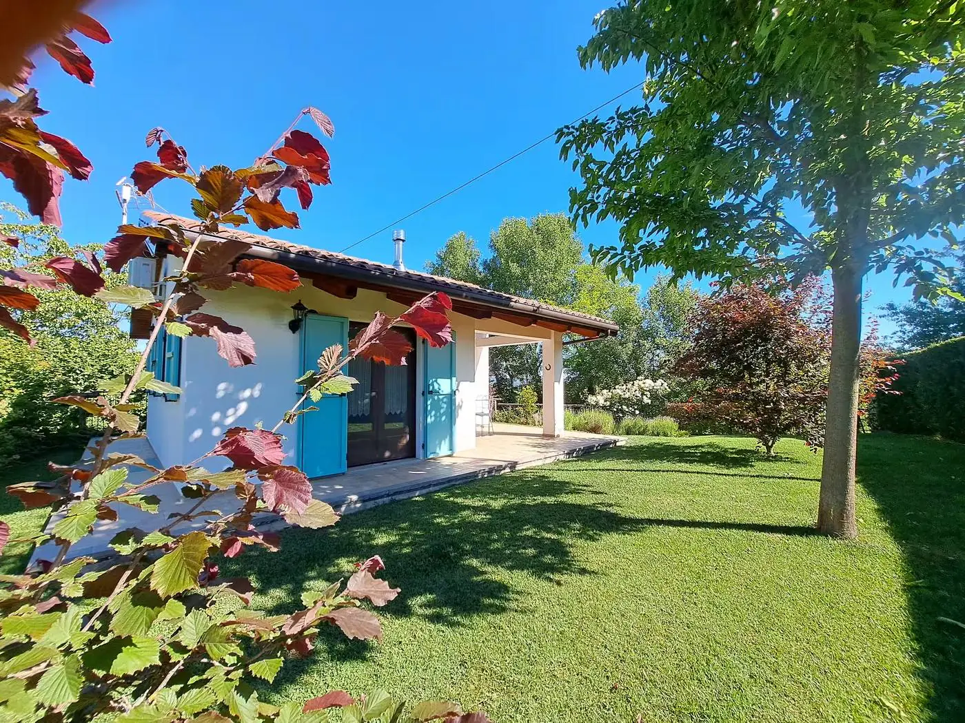 Il Ciabot di Rosa with blue shutters and a sunny lawn